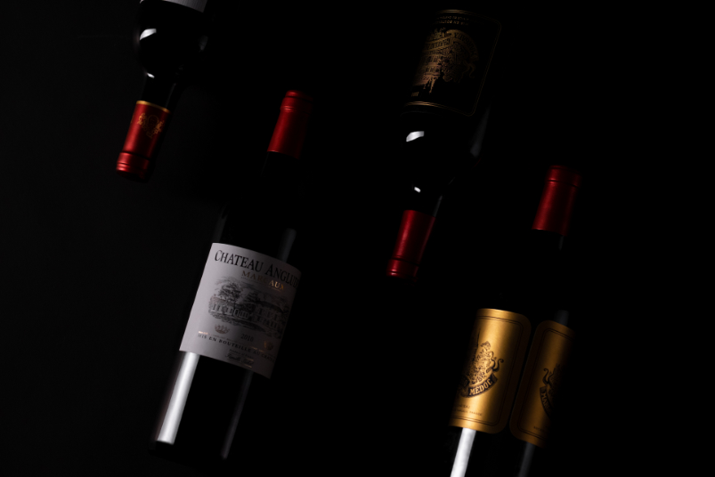 L’ancrage – Maison Sichel Composition artistique de bouteilles de la Maison Sichel, dont Château Angludet, sur fond noir